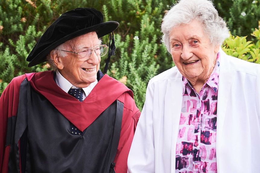 David Bottomley smiles wearing his university graduation gown while looking at his wife Anne.