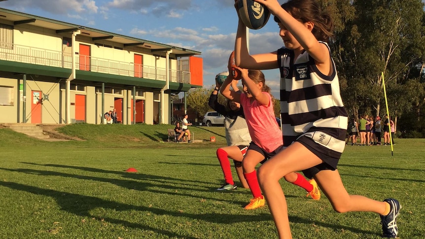 Young footballers in Darebin do leg exercised on a football oval.