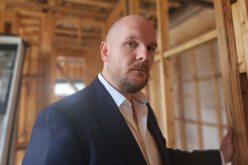 a man in a suit standing at a construction site