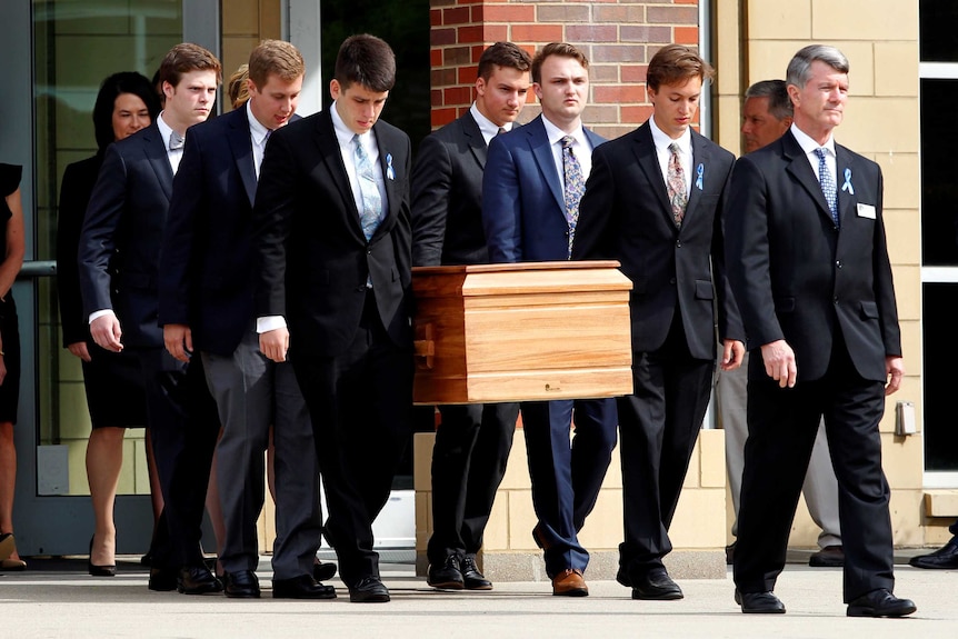 The casket of Otto Warmbier is carried to the hearse.