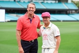 Glenn McGrath stands on the SCG next to Australia's David Warner who is wearing his Test whites and a pink cap.