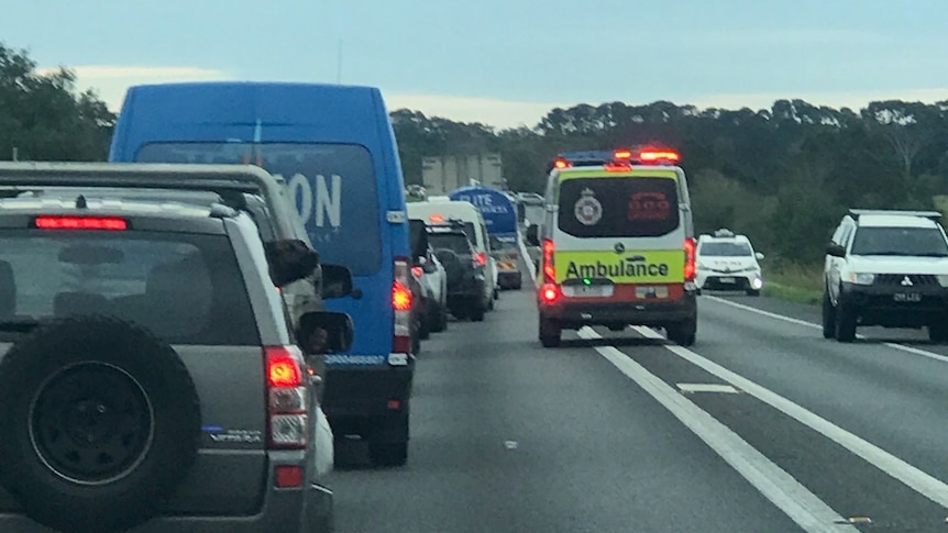 Ambulance drives through heavy traffic