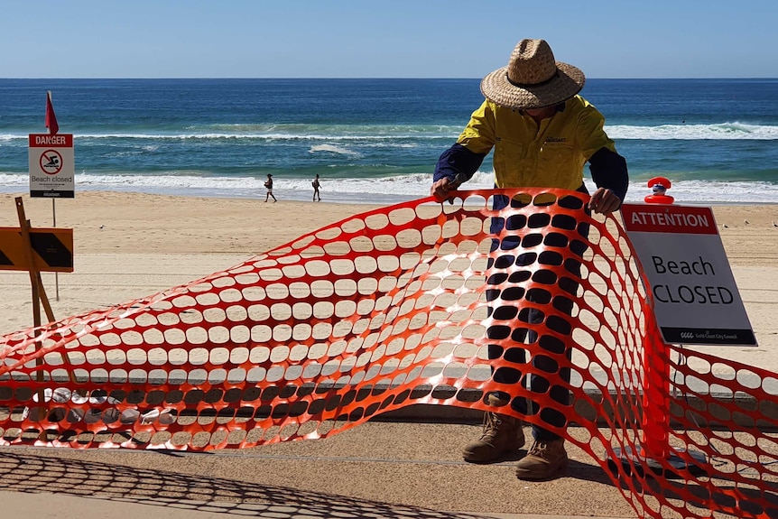 A council worker removes barriers installed at Surfers Paradise on the Gold Coast.
