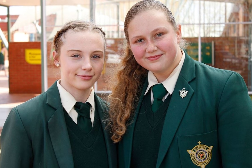 Ella Digney and Ella Purcell smile for the camera in their school uniforms.