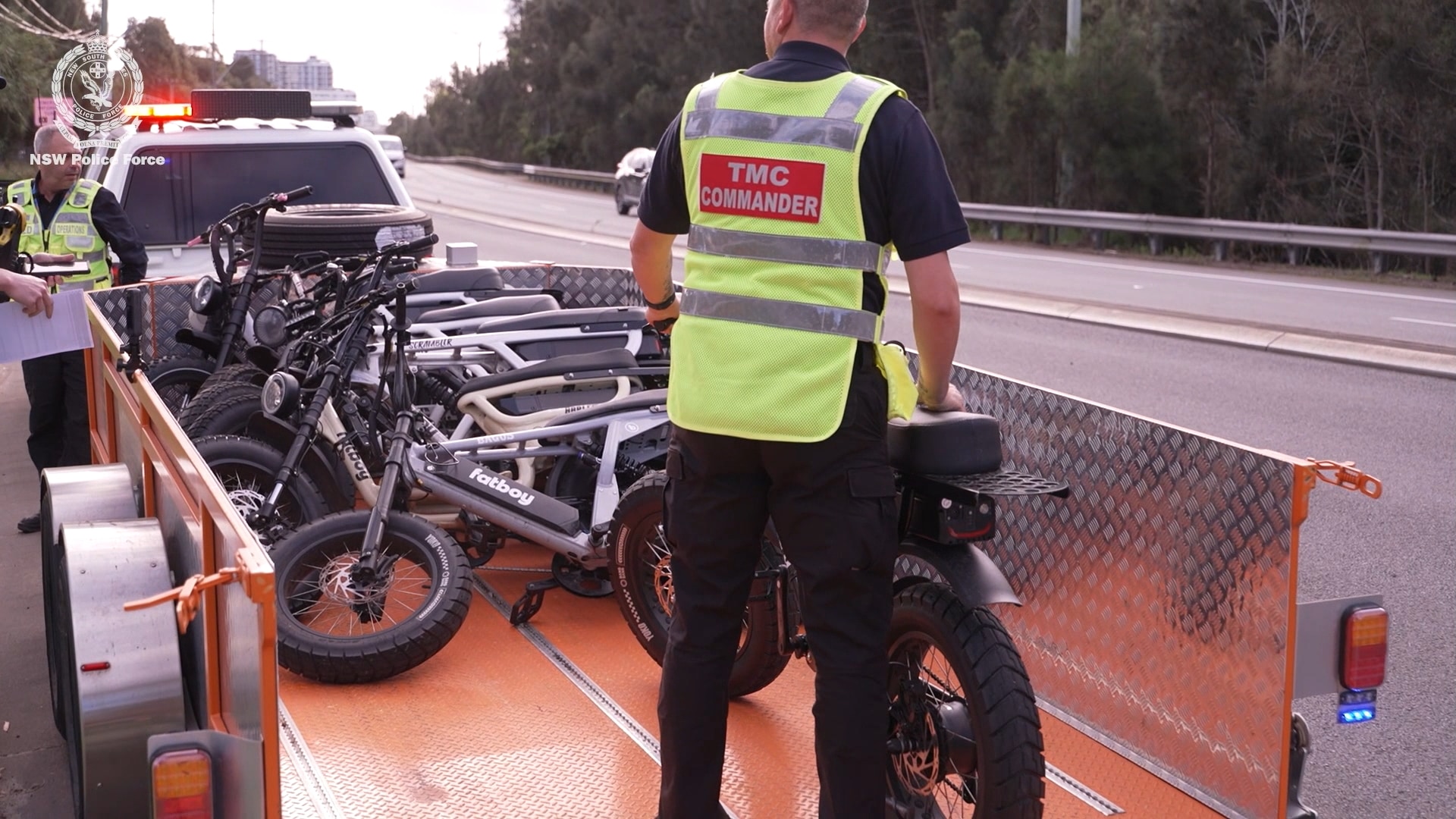 image of TMC officer with e-bikes in the back of a trailer