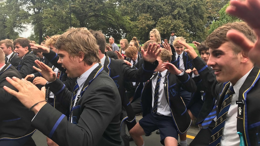 School boys in their uniform performing the haka