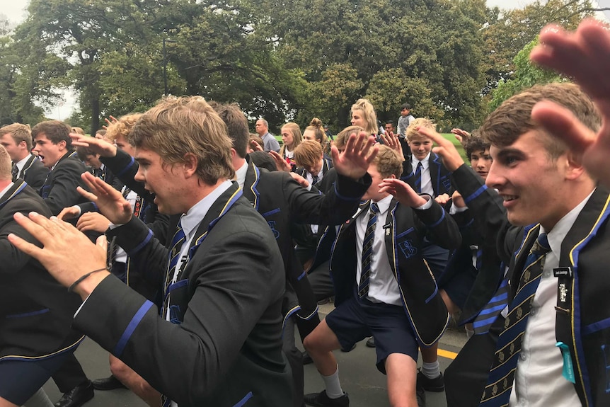 School boys in their uniform performing the haka