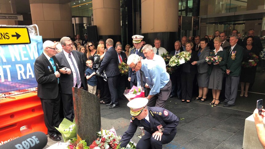 People lay flowers at a memorial for the Hilton Hotel bombing
