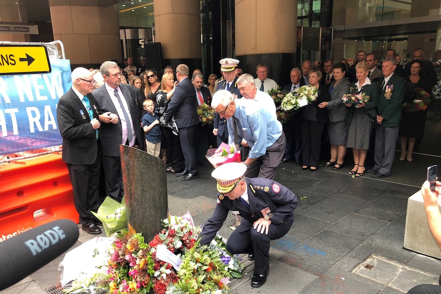 People lay flowers at a memorial for the Hilton Hotel bombing