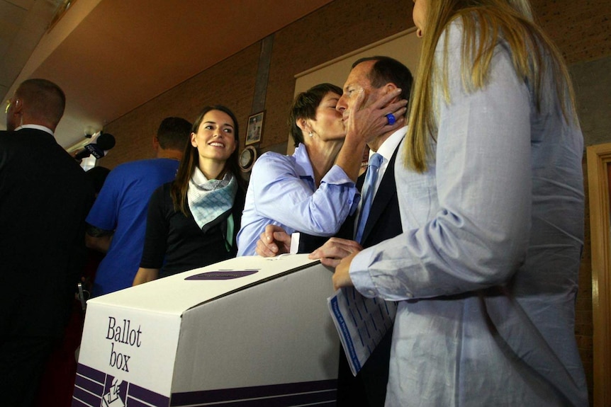 Mr Abbott receives a kiss from wife Margie after voting.