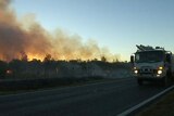 Blaze burns along a road near Biboohra, north of Mareeba, at dusk.