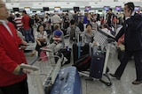 Stranded travellers gather at the Qantas check-in area at Hong Kong's international airport