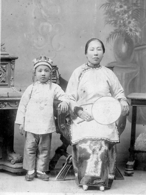 Formal black and white photo of woman and young boy in traditional chinese clothes 