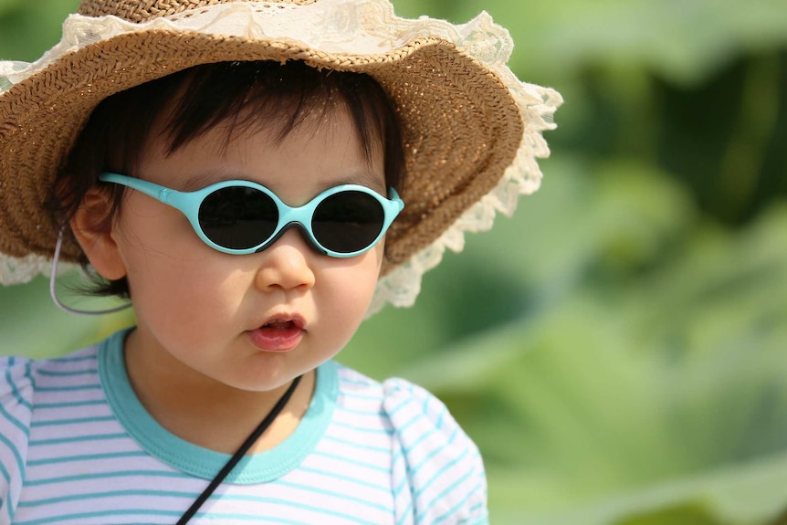 Child wearing sunglasses and a hat