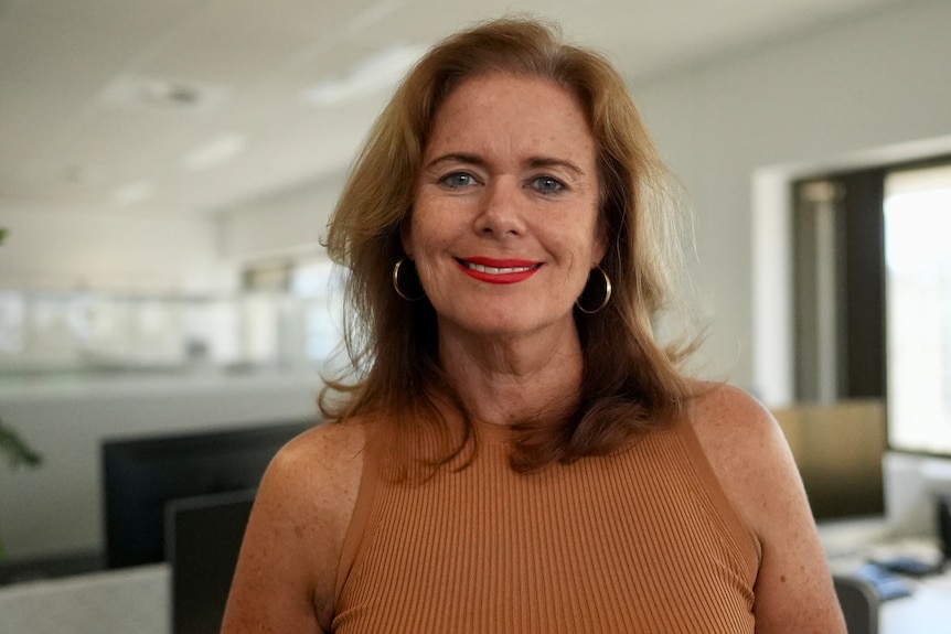 A woman stands in an office.