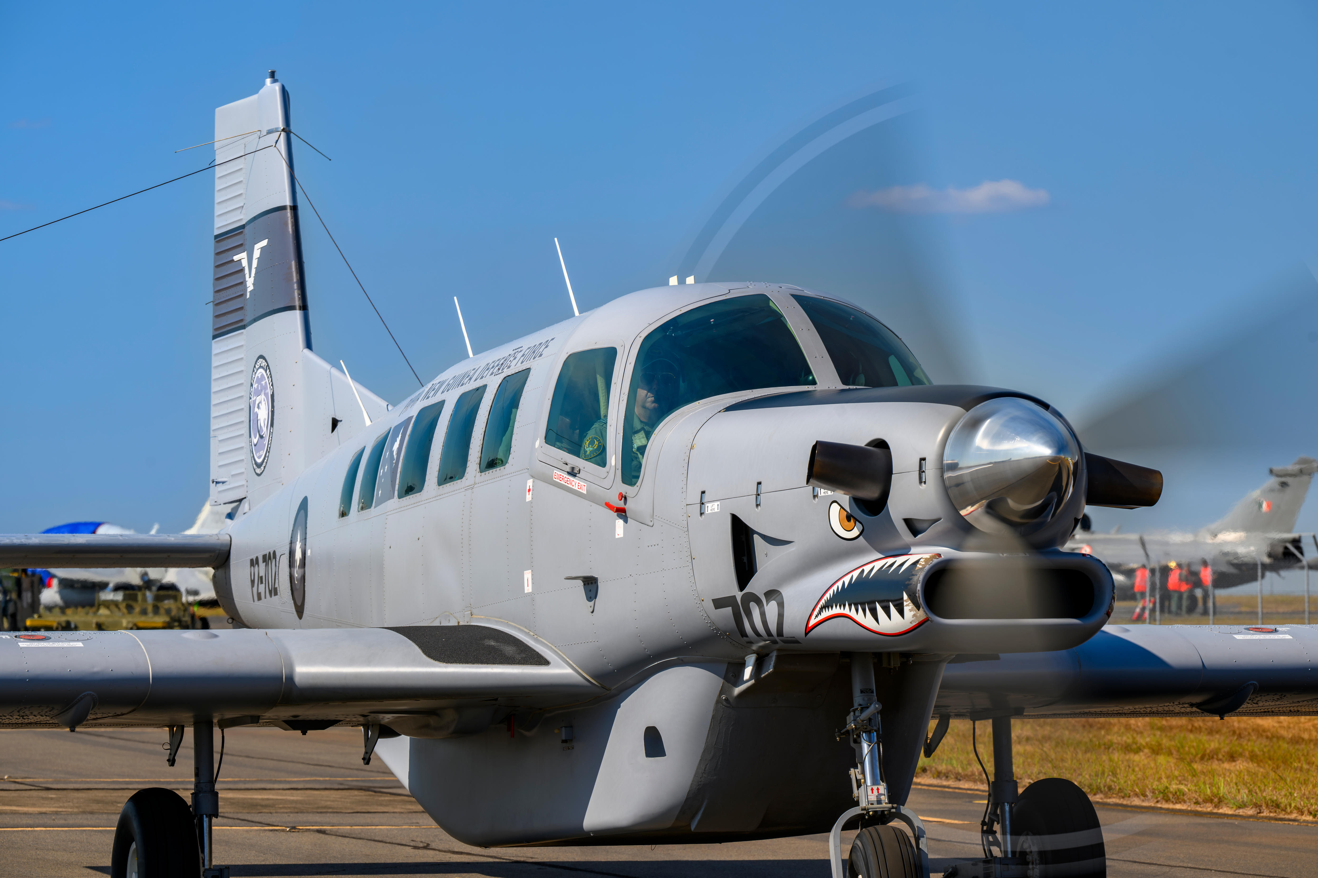 A propellor plane with a shark's face painted on it.