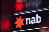 NAB sign with red star logo and 'nab' in white lettering. Red star reflects off corresponding roof and walls.