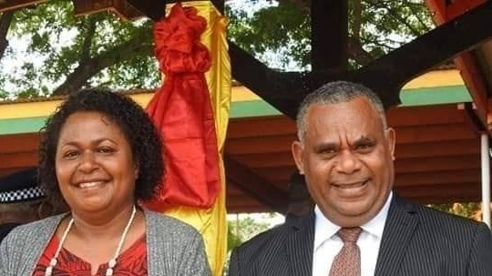 Vanuatu Deputy Prime Minister Jotham Napat standing next to a woman in red dress.