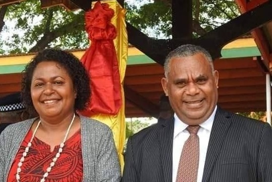Vanuatu Deputy Prime Minister Jotham Napat standing next to a woman in red dress.