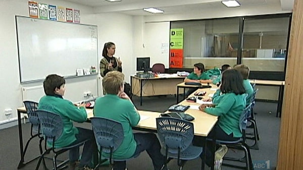 A primary teacher in front of a small group of children