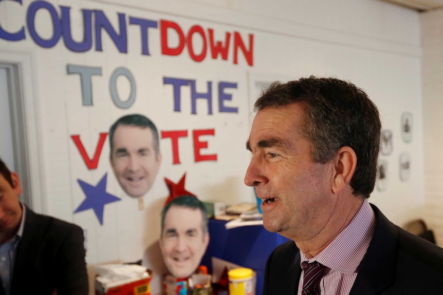 Ralph Northam stands in front of a sign saying "countdown to the vote".