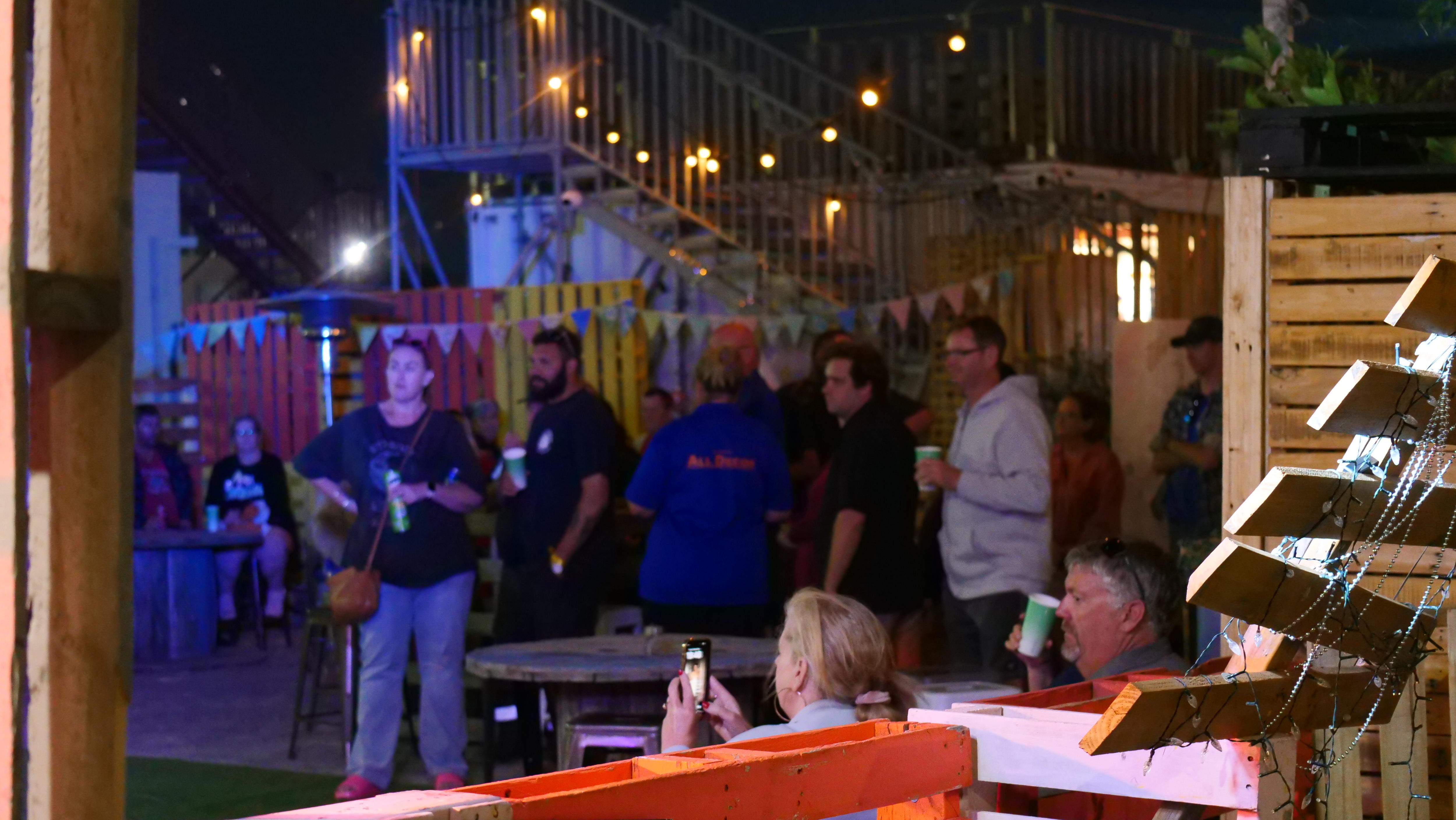 En un evento, varias personas se quedan paradas y observan a alguien hablar. 