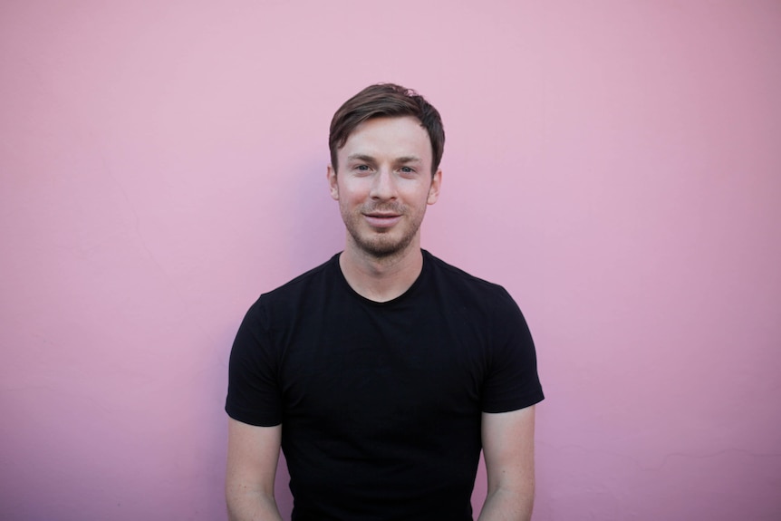 James Bowe standing in front of a pink wall.