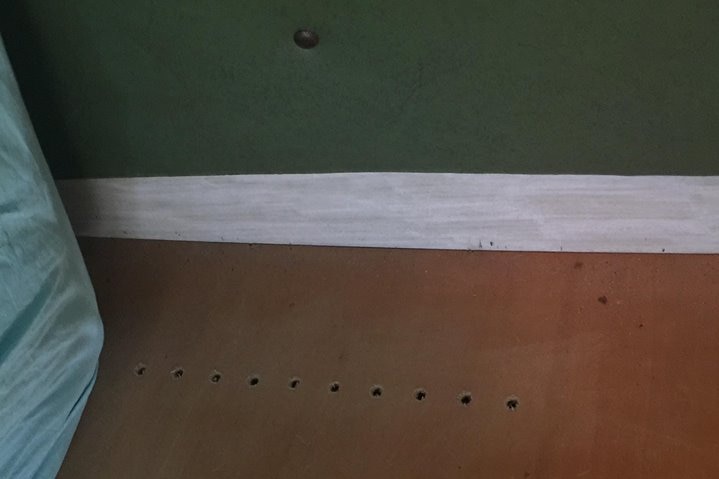 Holes drilled into the wood underneath a mattress in a caravan.
