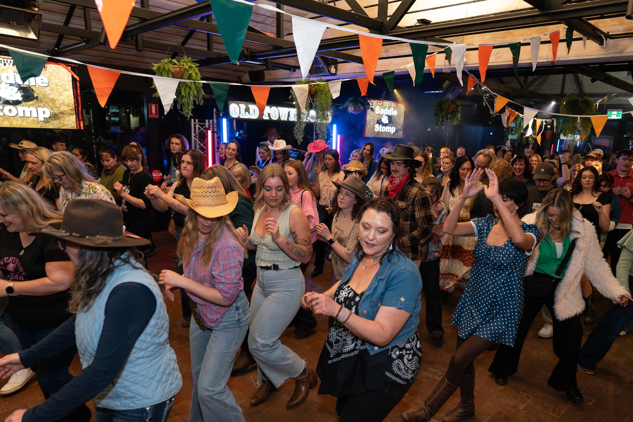Un gran grupo de personas baila en la pista de baile de un pub.