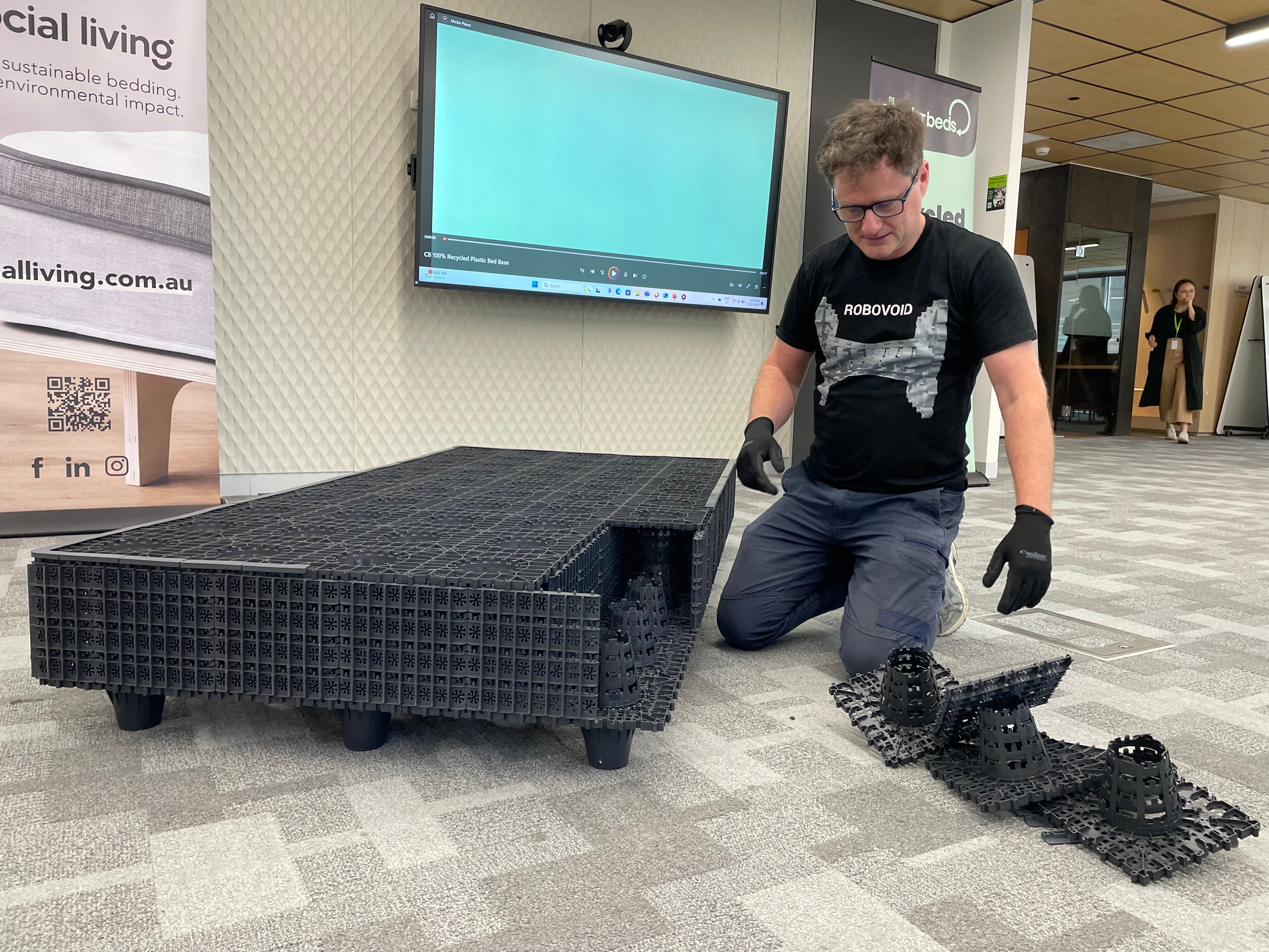 A man constructing a plastic bed base
