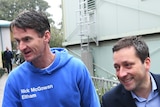 Nick McGowan, in a blue hoodie reading 'Nick McGowan Eltham' next to a smiling Matthew Guy in a suit, both reaching out hands.