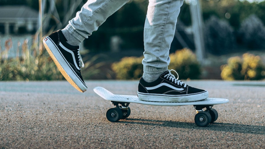 A person riding a skateboard in a rubber soled pair of sneakers.