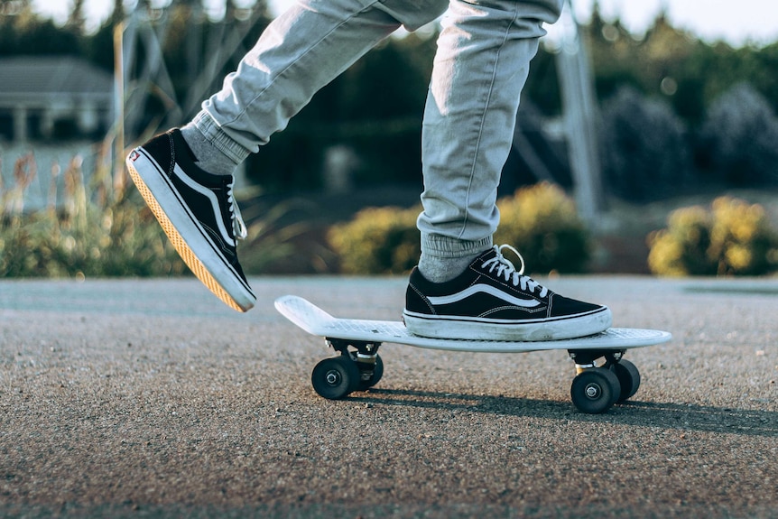 A person riding a skateboard in a rubber soled pair of sneakers.