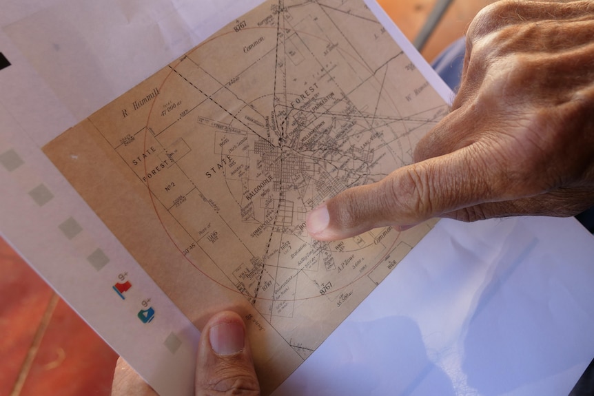 Man points to a spot on an old map.