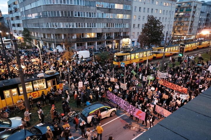 At least hundreds of protesters are seen blocking a main street with trams unable to pass in the centre.