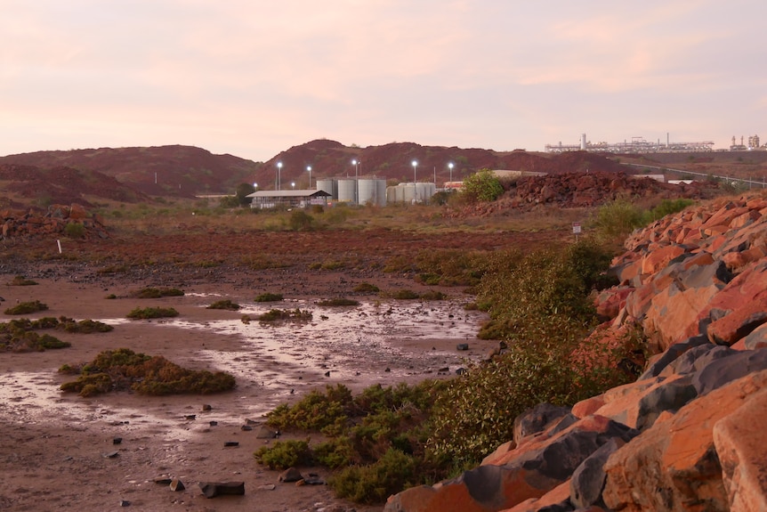 Mining projects at dusk, with red rocks in the foreground