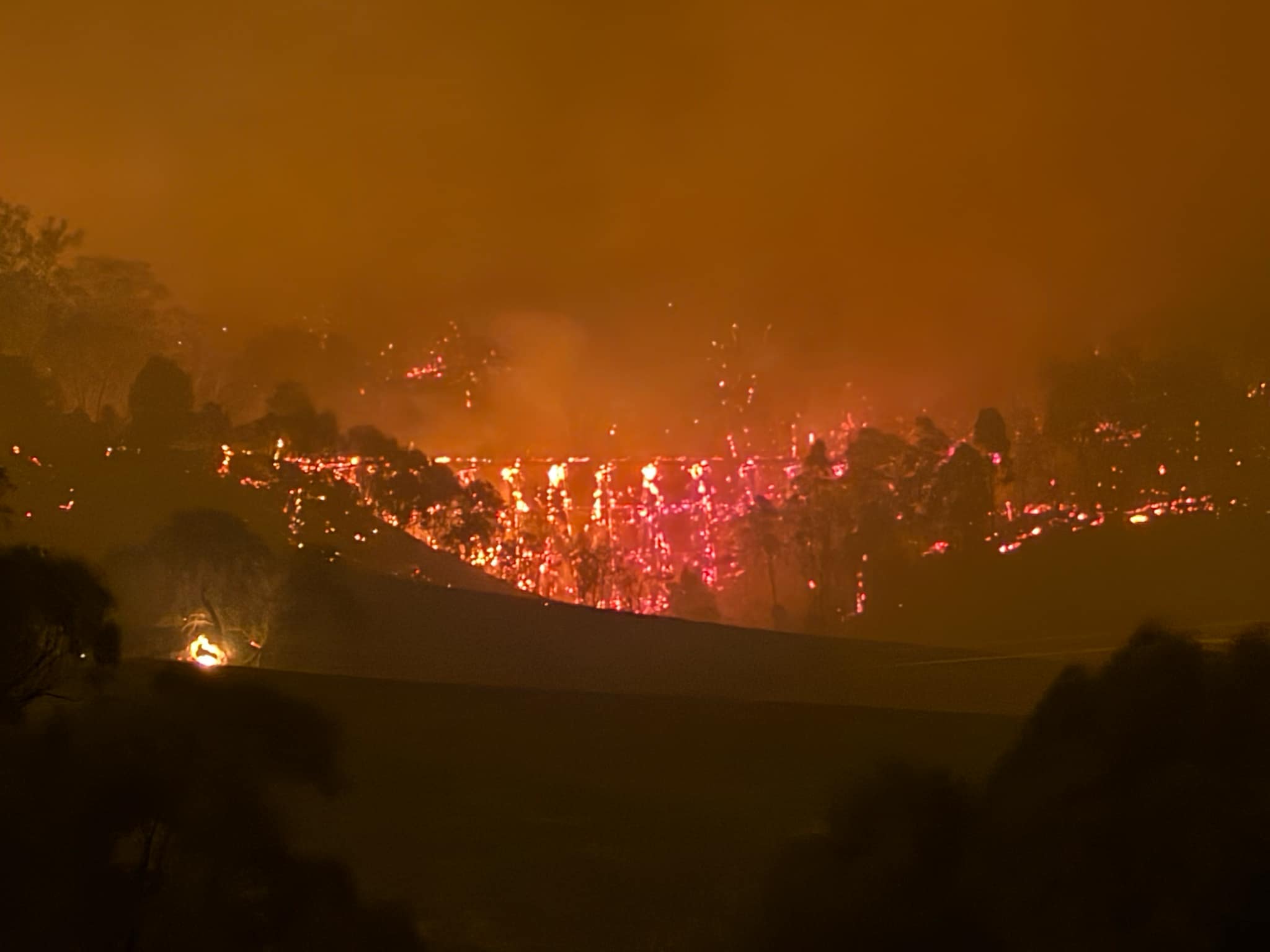 Las llamas consumen un puente en un paisaje en llamas