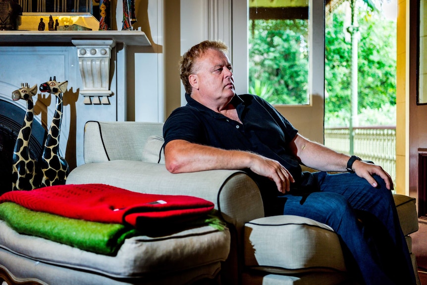 A man sits in a lounge chair.