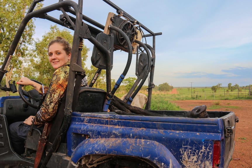 Woman driving buggy with pig in the back