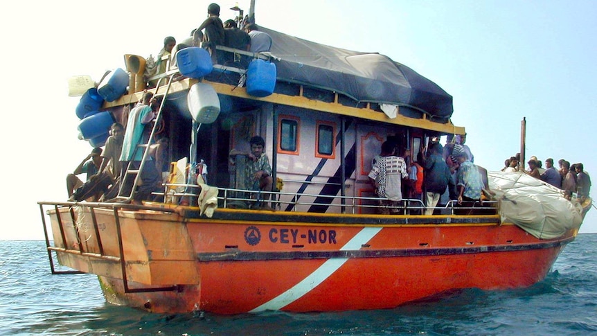 Sri Lankans asylum seekers stay on their traditional boat near Dili's port. (AFP: Antonio Dasiparu)