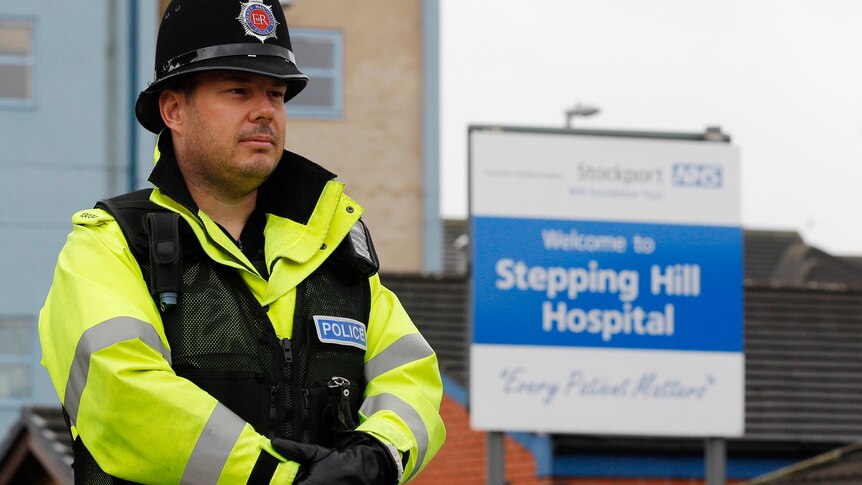 A police officer stands outside the entrance to Stepping Hill hospital in Stockport, northern England.