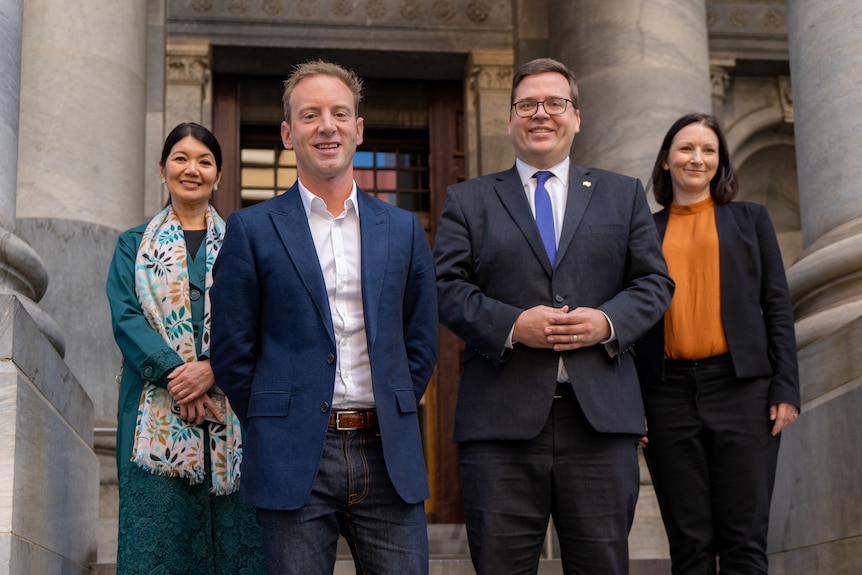 Two men and two women in front of columns at Parliament House