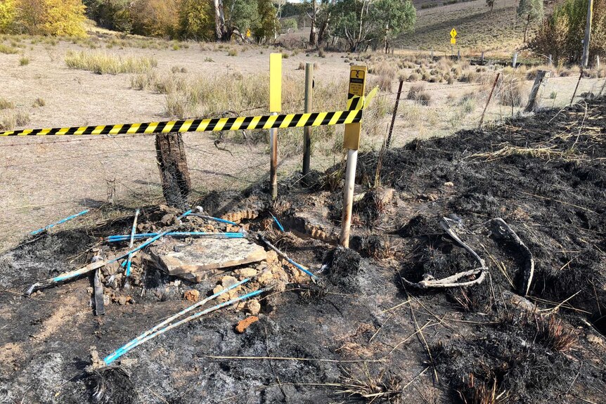 A Telstra telecommunications pit which is burnt out by fire