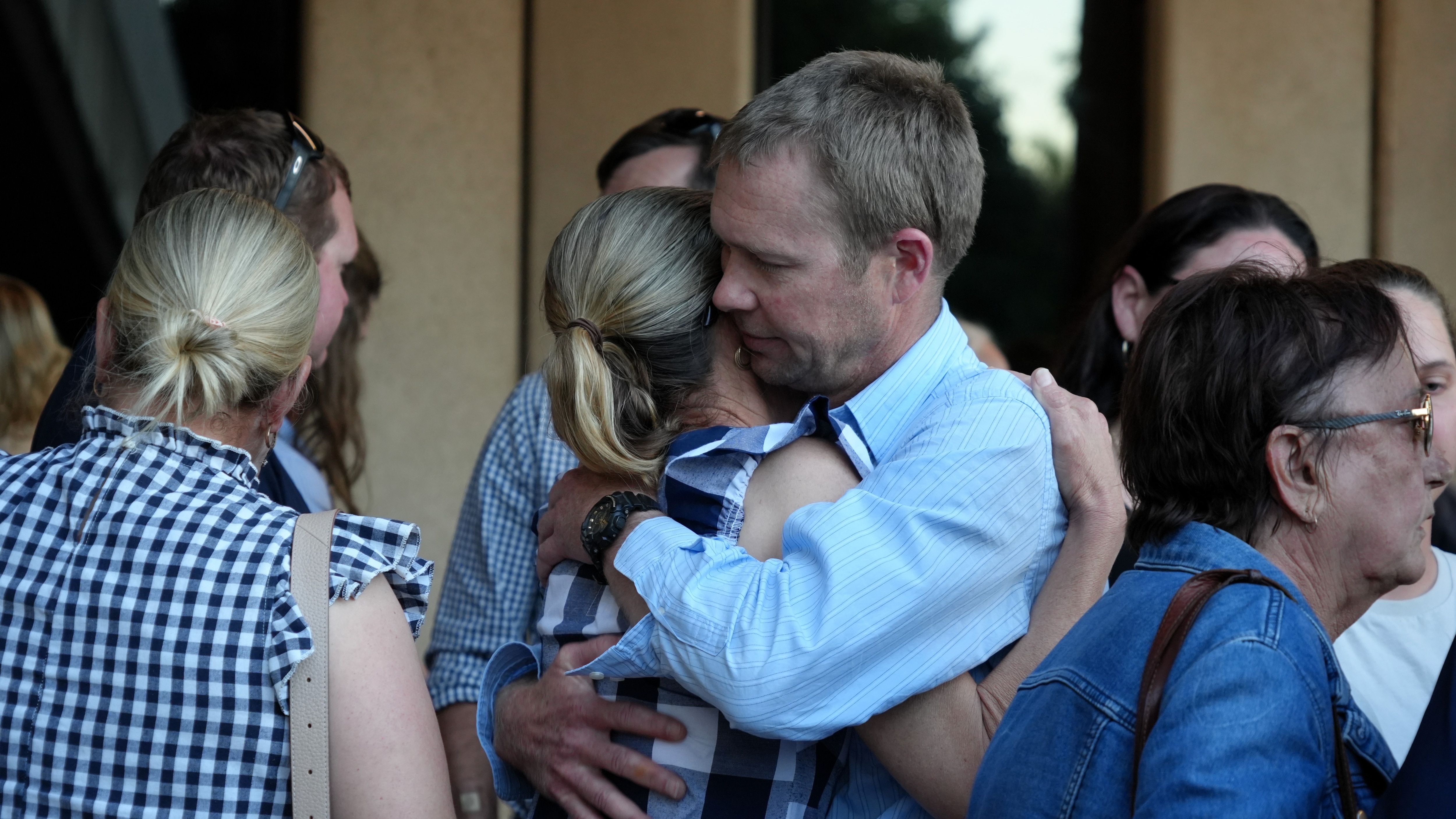 A group of people gathering and hugging. 