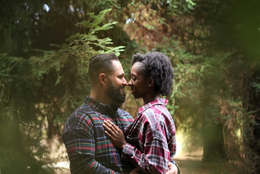 A man and woman hugging and smiling and looking into each others' eyes