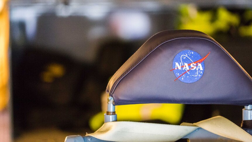 A chair headrest with the NASA logo imprinted on the back of it.