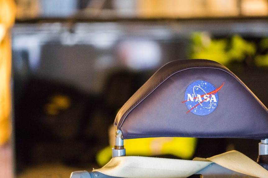A chair headrest with the NASA logo imprinted on the back of it.