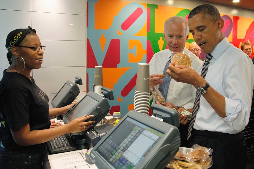 Joe Biden helps Barack Obama pick a pack of cookies to buy at a food shop