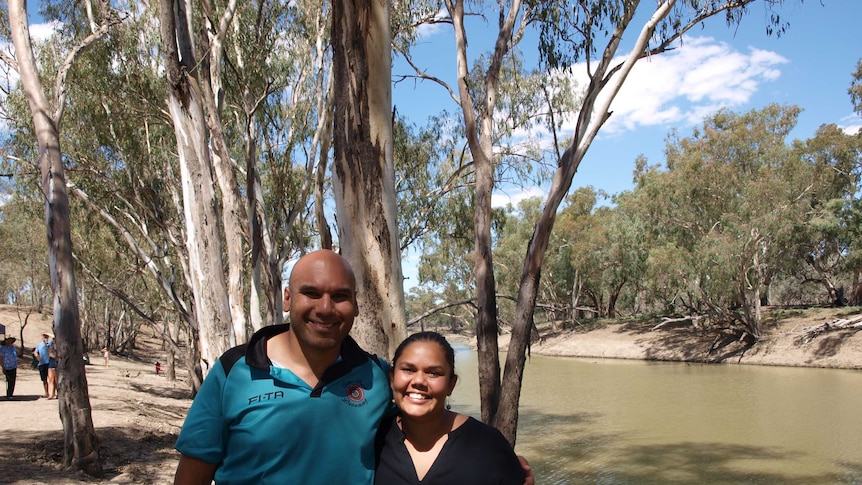 Two people standing near river