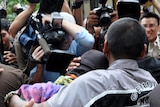 The 14-year-old - being led from court on Tuesday in this picture -  faces three potential convictions.